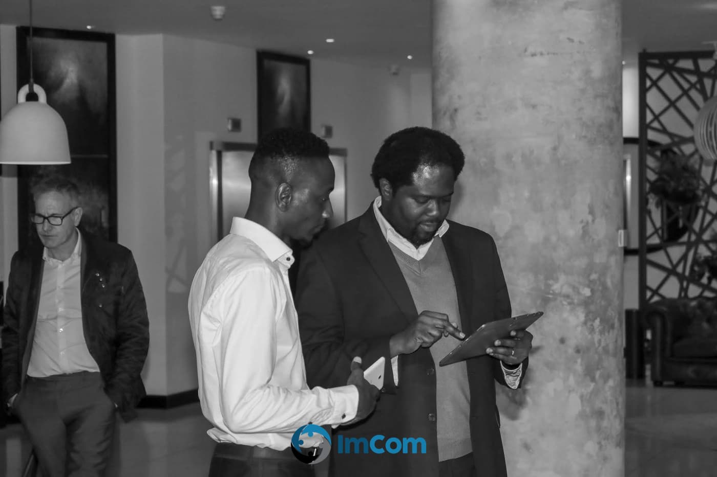 Two attendees comparing notes on a tablet