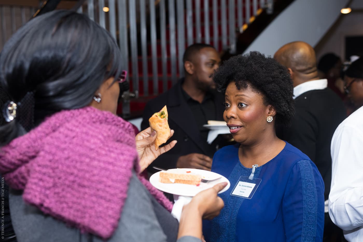 Two attendees laughing together over refreshments