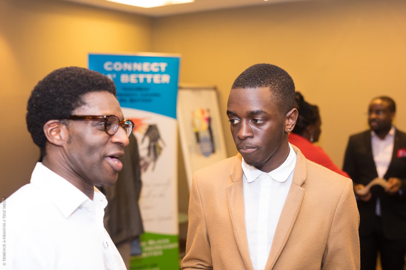 Two attendees beside the Connect4Better banner