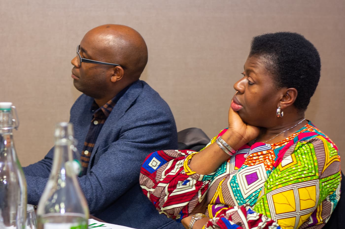 Two attendees listening at the front table