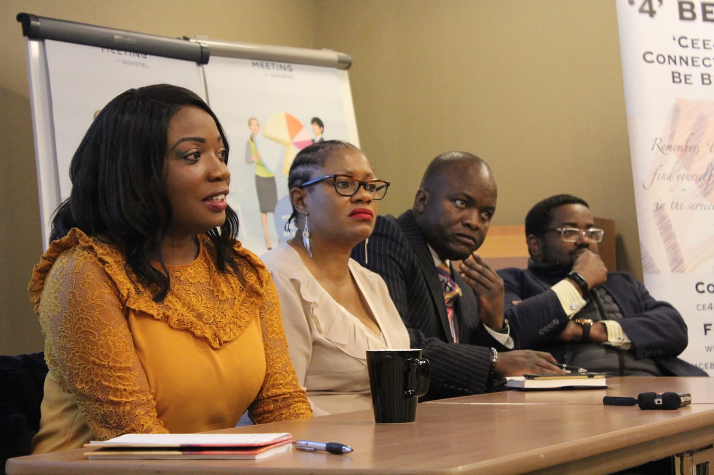 Three attendees seated together, listening during the panel session